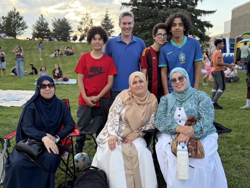 Nicolas Plourde entouré d'une famille lors d'une fête de quartier