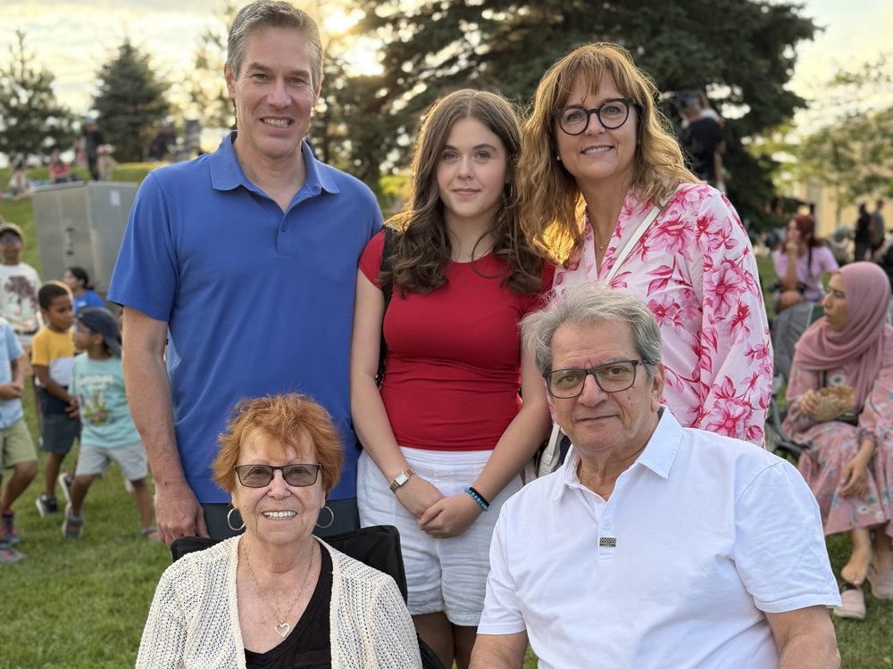 Nicolas Plourde en compagnie d'une famille lors d'un événement communautaire